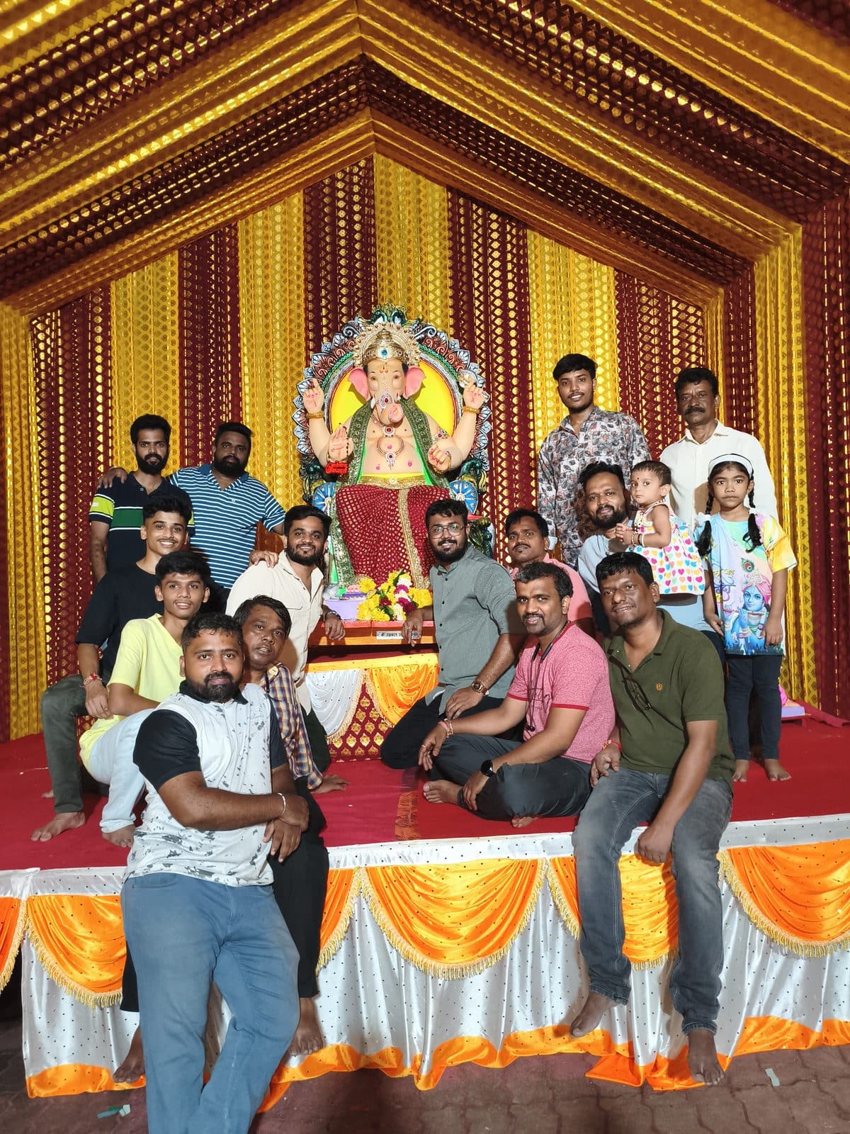 मंडपाच्या सजवलेल्या रंगमंचावर श्रींसमोर उभे मंडळाचे कार्यकर्ते