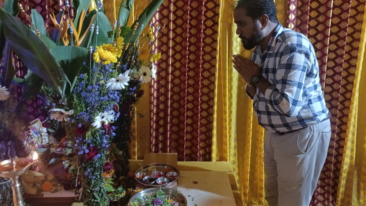 पूजेच्या आरासेसमोर हात जोडून उभा असलेला भक्त — मातोश्री शिवगर्जना गणेशोत्सव २०२५, परेल-भोईवाडा